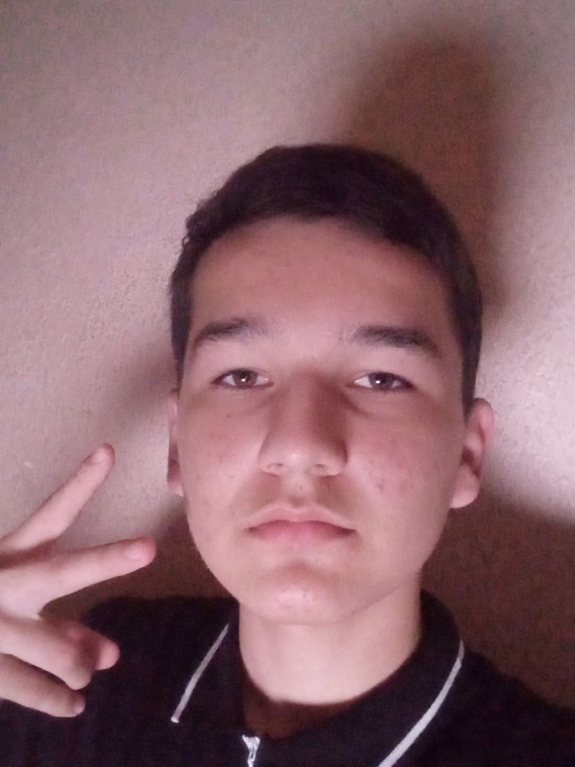 Diyorbek looking at camera with peace sign